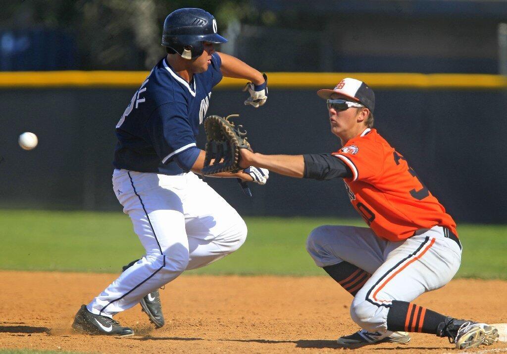 Newport Harbor High's Keith Marshall, left, runs back safely to first base against Huntington Beach's Jake Brodt in a Sunset League game on Tuesday.