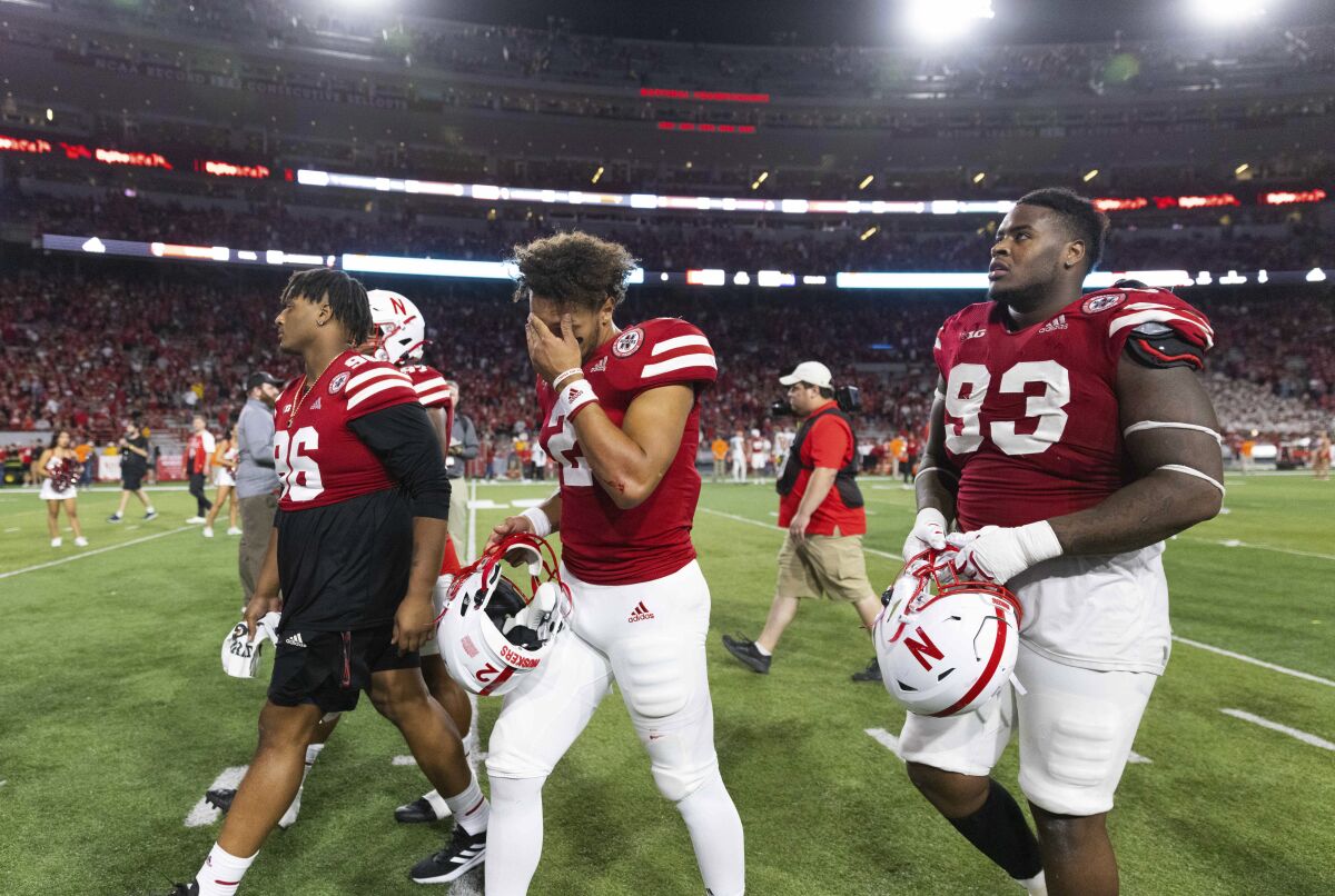 Nebraska quarterback Adrian Martinez (2) wipes his brow while leaving the field alongside Marquis Black (96) and Damion Daniels (93) following the team's 32-29 loss to Michigan in an NCAA college football game Saturday, Oct. 9, 2021, at Memorial Stadium in Lincoln, Neb. (AP Photo/Rebecca S. Gratz)