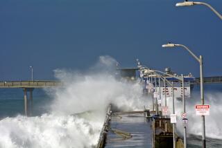 Waves crash over the Ocean Beach Pier, tearing railings off on Friday, October 20, 2023.