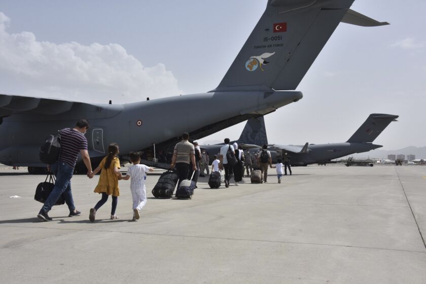 Turkish nationals board a Turkish Air Force plane at Kabul airport, Afghanistan, Wednesday, Aug. 18, 2021. Turkey's defense ministry says a Turkish Air Force plane has ferried some 200 Turkish citizens from Kabul to Pakistan as nations continue to evacuate their citizens after the Taliban took control of Afghanistan.(Turkish Defense Ministry via AP)