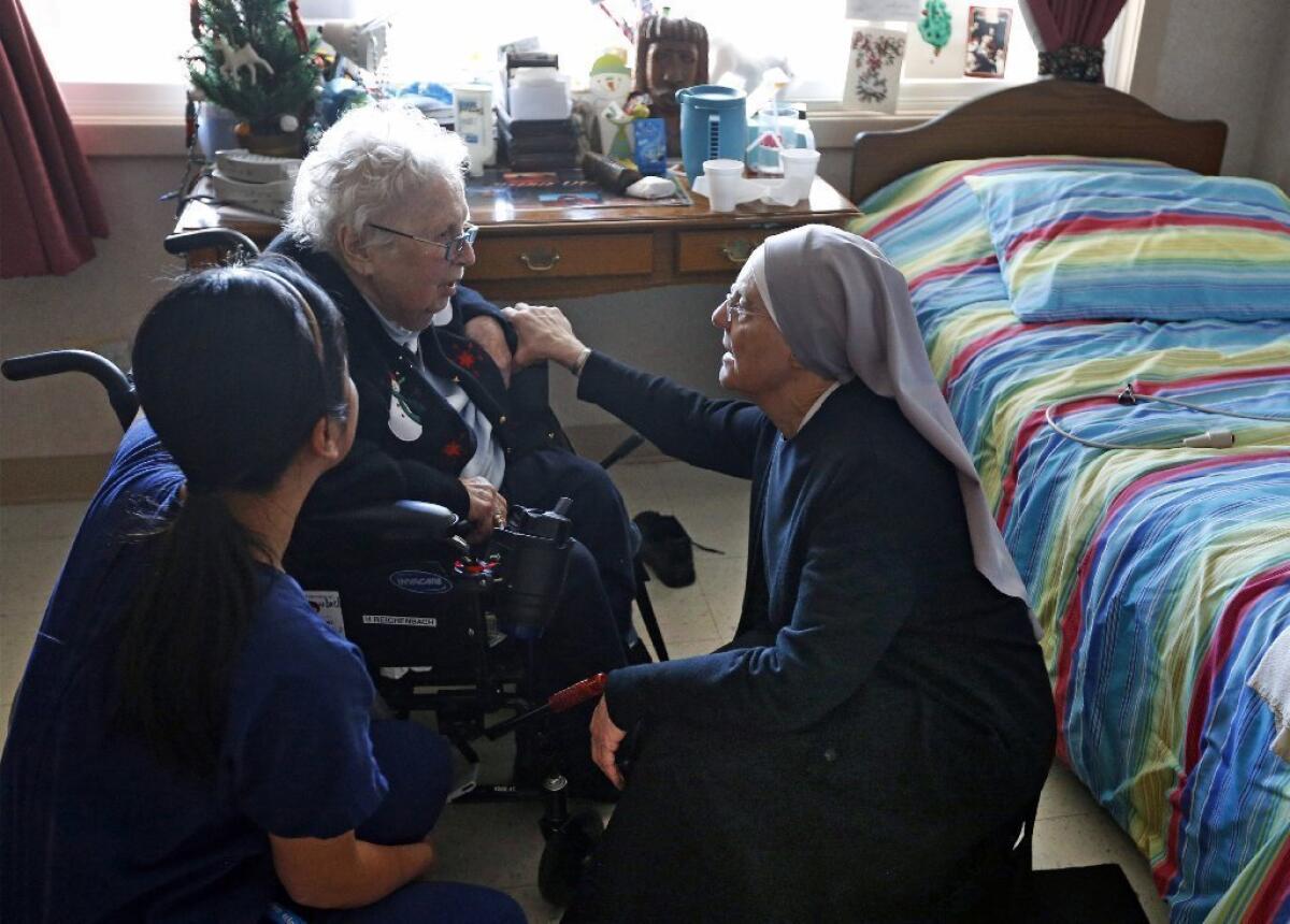 A nun and a nurse visit with a resident of a Little Sisters of the Poor home for the aged in Denver.