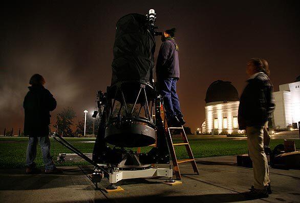Members of the Los Angeles Astronomical Society -- Gabriel Reyna, from left, Reynold Burbank and Mary Brown -- try to get a glimpse of the impact through their 25 1/2-inch telescope on the Griffith Observatory lawn in Griffith Park. Clouds blocked their view, but they didn't miss anything. The expected plume of debris did not materialize.