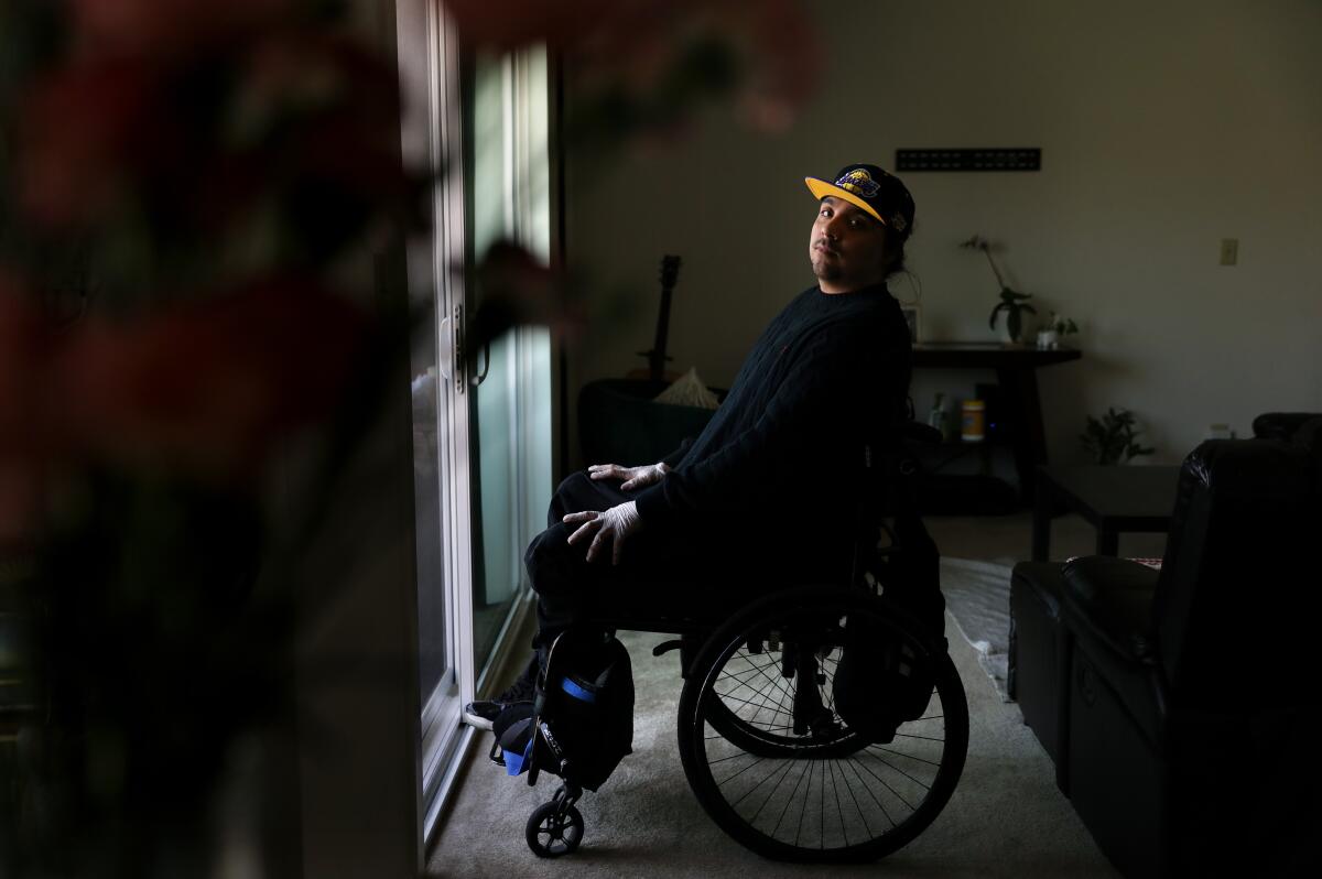 Danny Pena in a wheelchair in his apartment