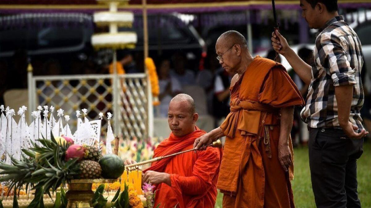 A monk lights a candle at a shrine during a Buddhist prayer for the missing children near Tham Luang Nang Non cave on July 1.