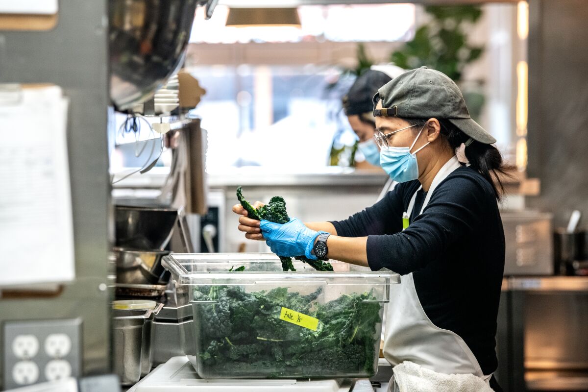 Elaine Chang y Steven Park trabajan dentro de la cocina de Yang’s Kitchen.