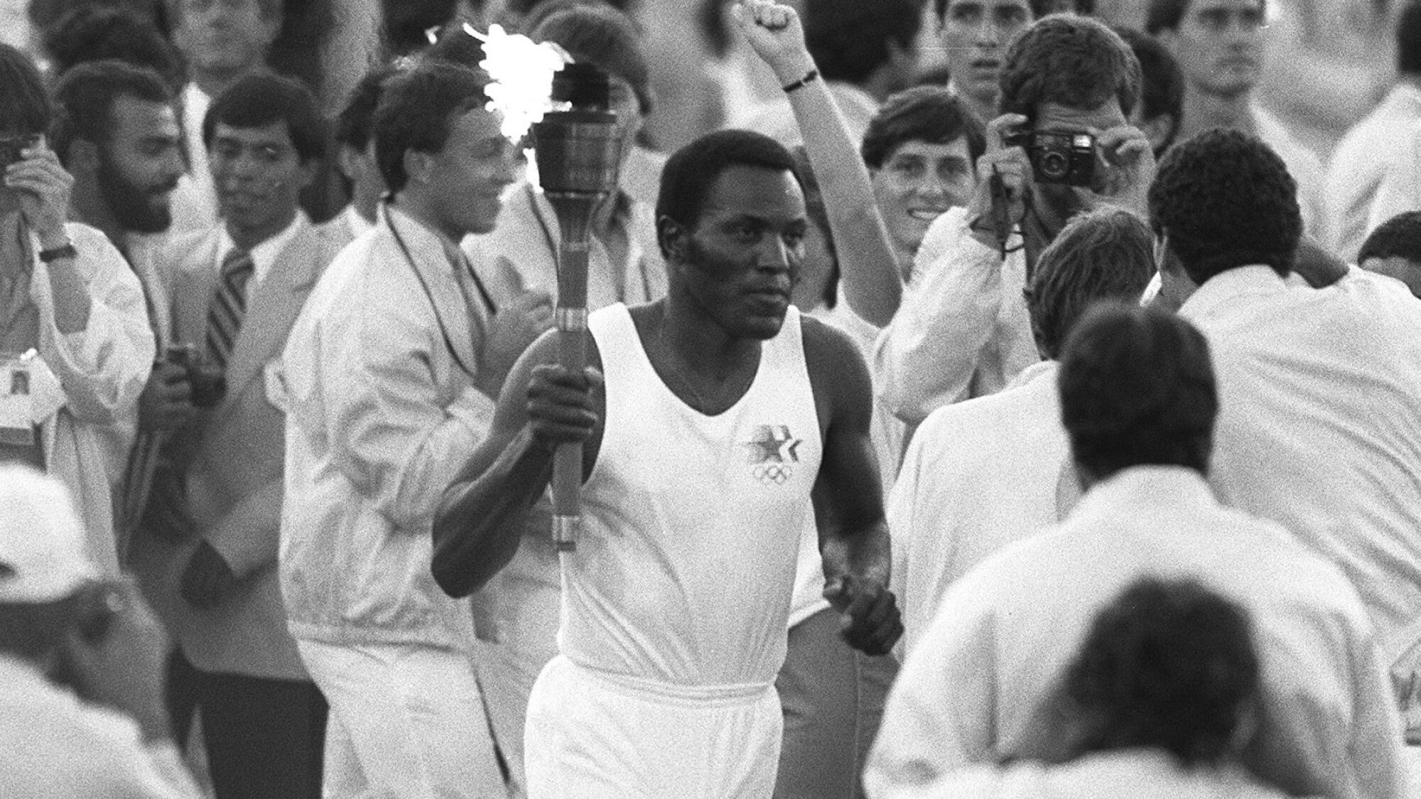 Rafer Johnson runs around the track at the Coliseum before lighting the Olympic flame on July 28, 1984.