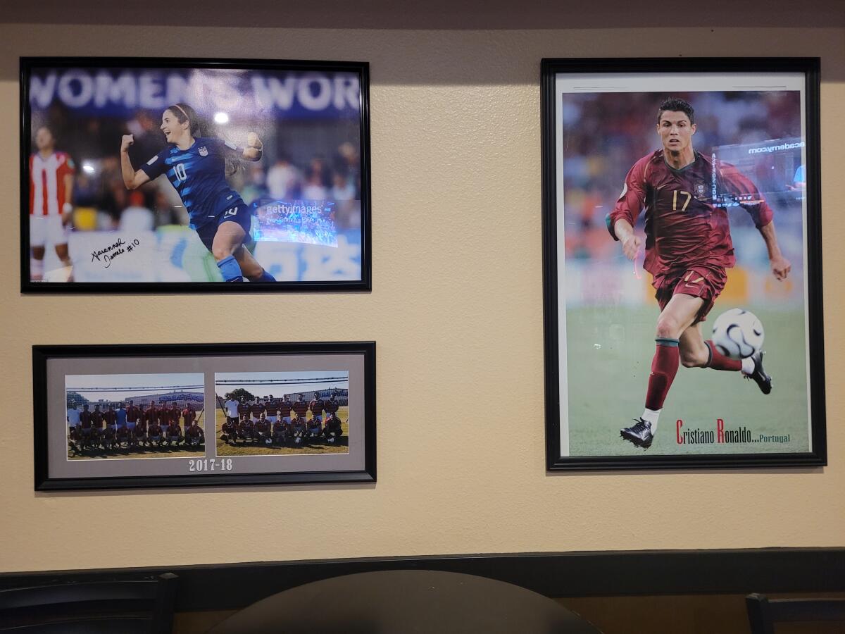 Photos of USWNT's Savannah DeMelo and Portugal's Cristiano Ronaldo hang at D.E.S. Portuguese Hall in Artesia.