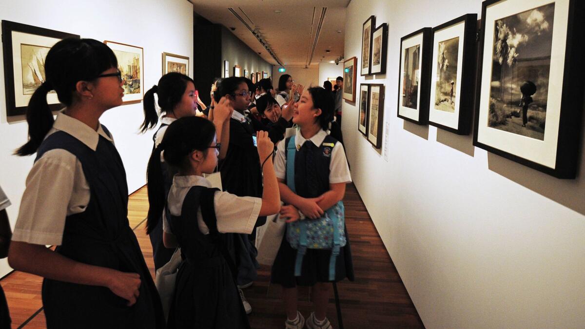 School children view art works in the National Gallery, formerly the City Hall and High Court building, in Singapore.