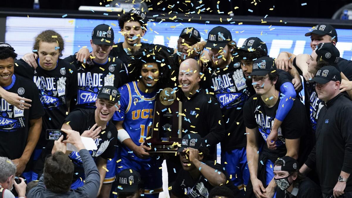 UCLA players and coach Mick Cronin celebrate after defeating Michigan in the Elite Eight of the NCAA tournament on Tuesday.