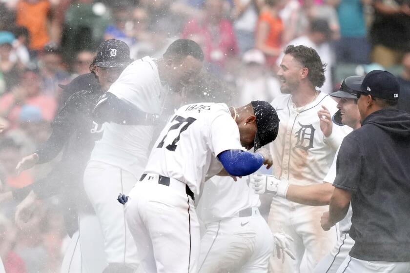 CORRECTS TO NINTH INNING FROM 10TH INNING - Detroit Tigers' Wenceel Perez, left, is surrounded by teammates after his sacrifice to score Justyn-Henry Malloy to defeat the Los Angeles Dodgers in the ninth inning of a baseball game, Sunday, July 14, 2024, in Detroit. (AP Photo/Carlos Osorio)