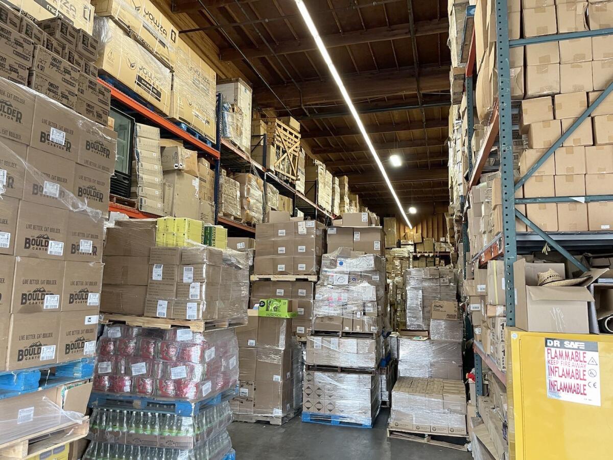 Stolen merchandise stacked in boxes on pallets and shelves in a large room