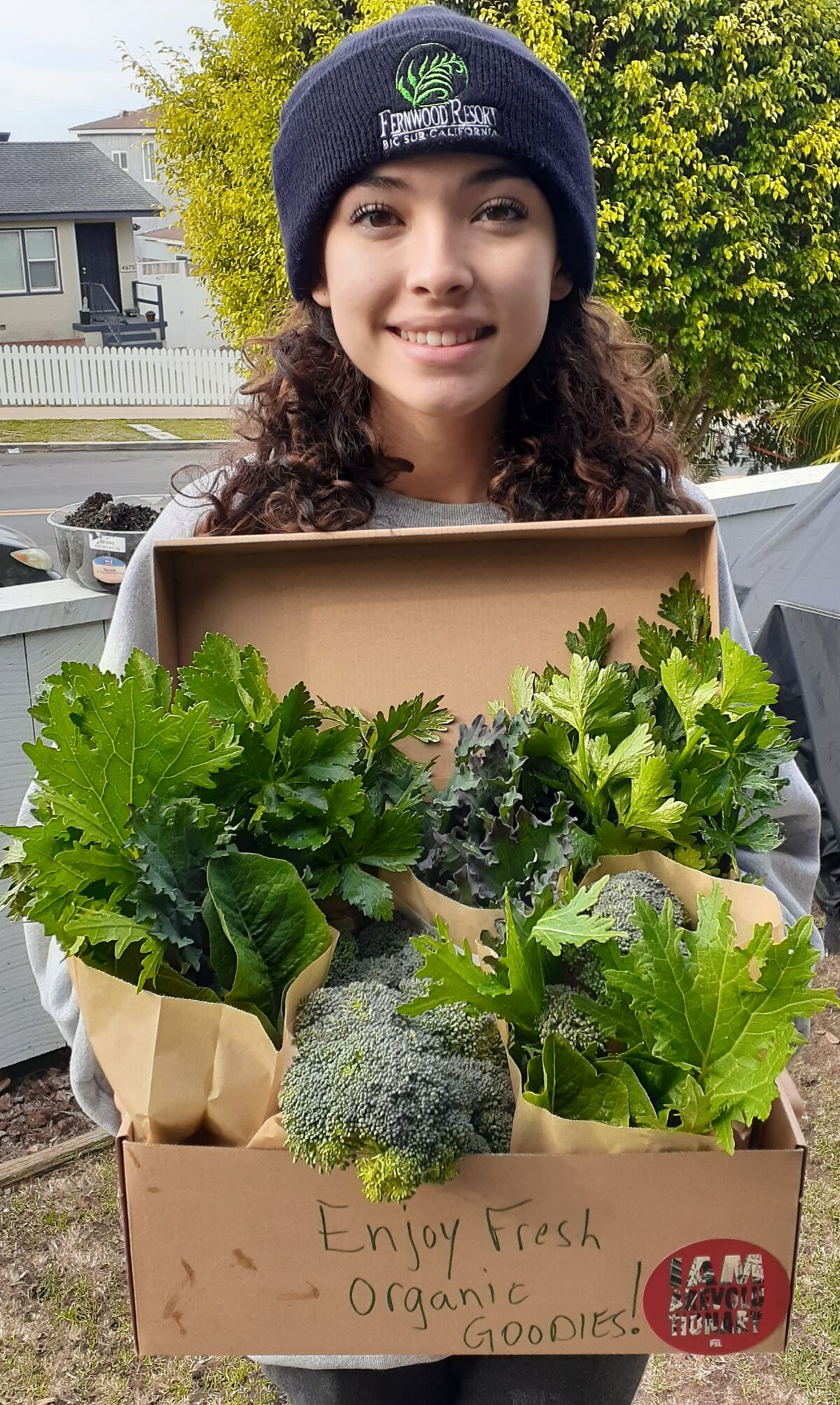 Point Loma High senior Fania Villarreal carries produce she grew to donate to Ocean Beach food pantry Loaves & Fishes.
