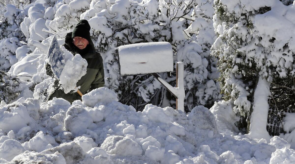 J.J. Laprise shovels his driveway in Scituate, Mass., on Friday.