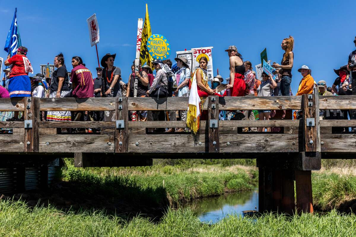 Climate activists and Indigenous community members on a bridge