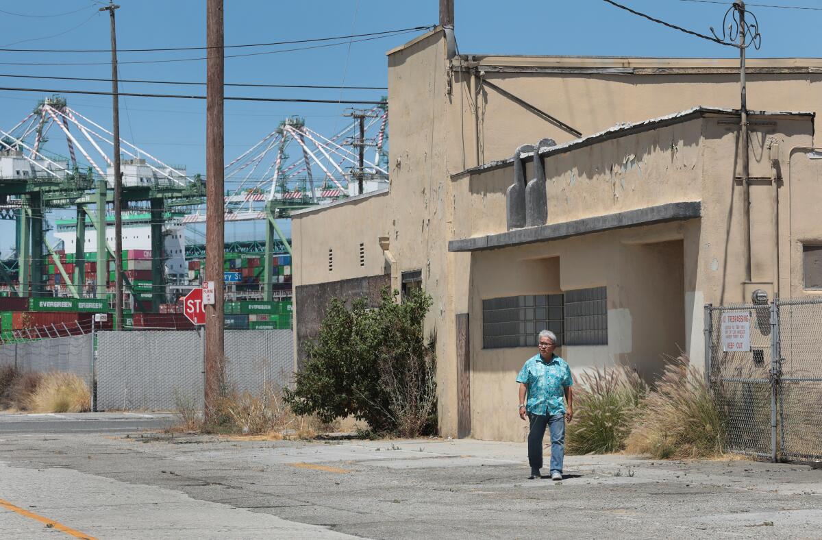 A man walks in front of buildings.