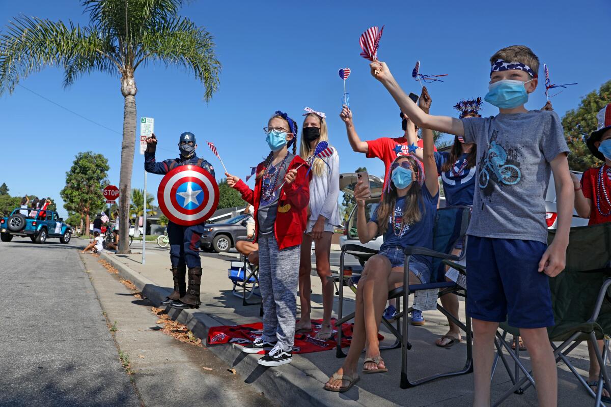 Spectators watch the OneHB Parade, a modified parade in Huntington Beach that let residents watch from their neighborhoods.