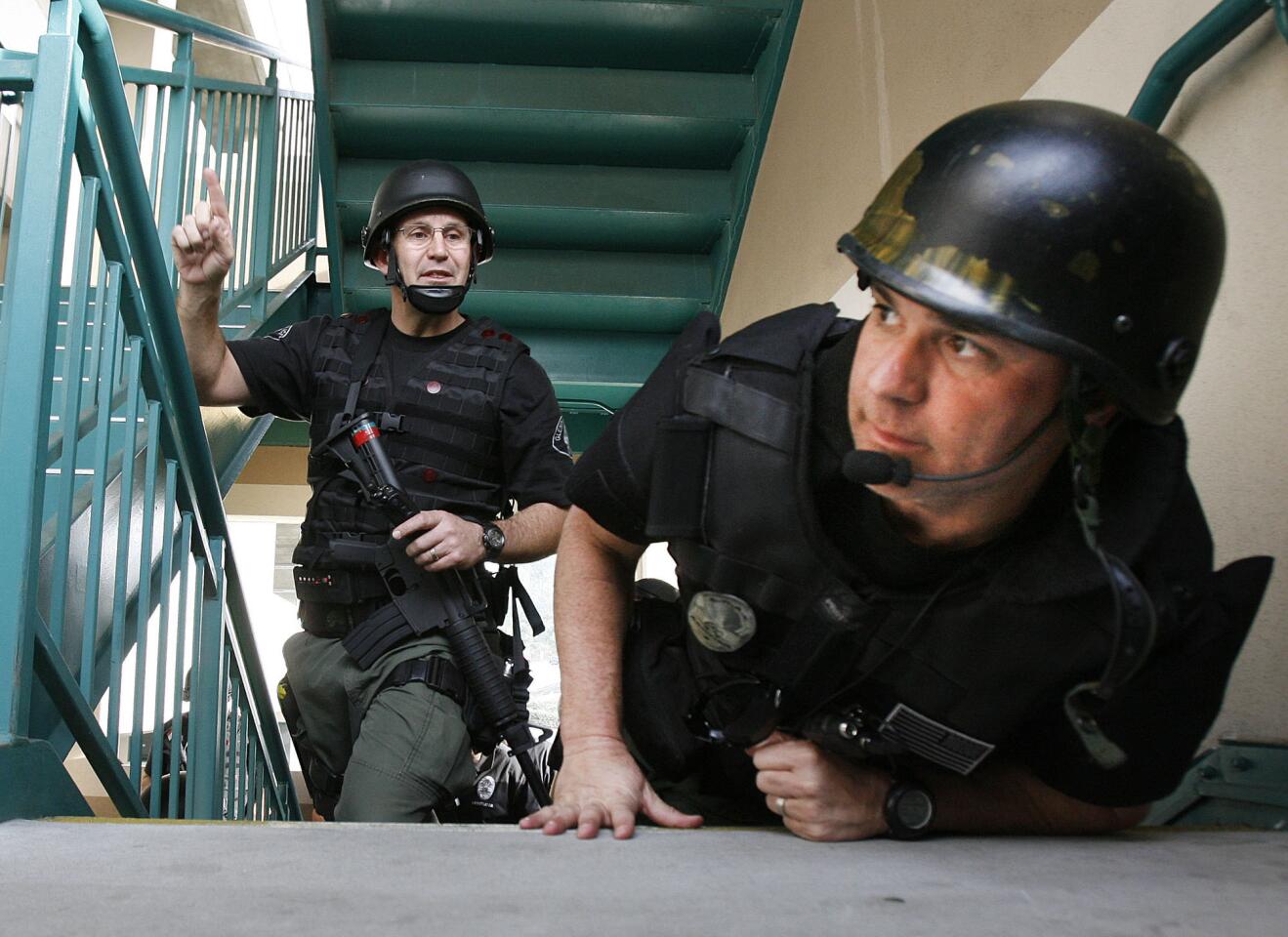 Glendale SWAT team members look around a corner to spot one of the hostages hiding at Glendale Community College on Wednesday, January 8, 2013. GPD, along with the Glendale College Police Department ran hostage scenarios to practice team responses.