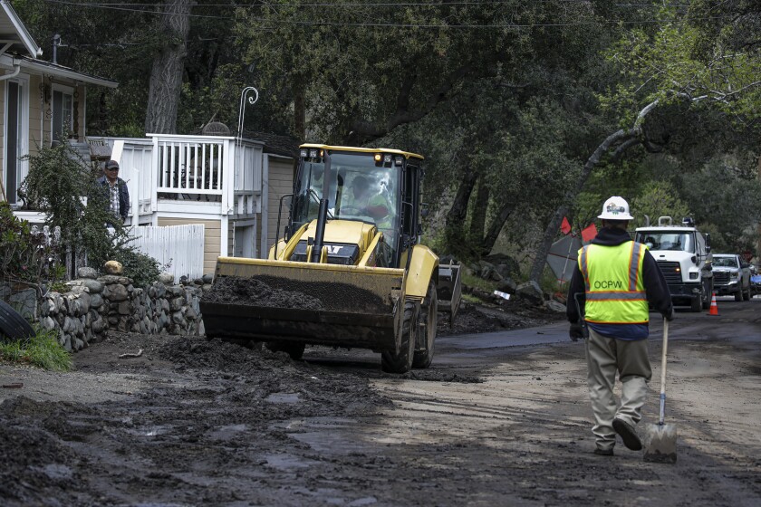 OC Public Works crew cleans street after a mudslide down fire-scarred mountainsides along Silverado Canyon Rd