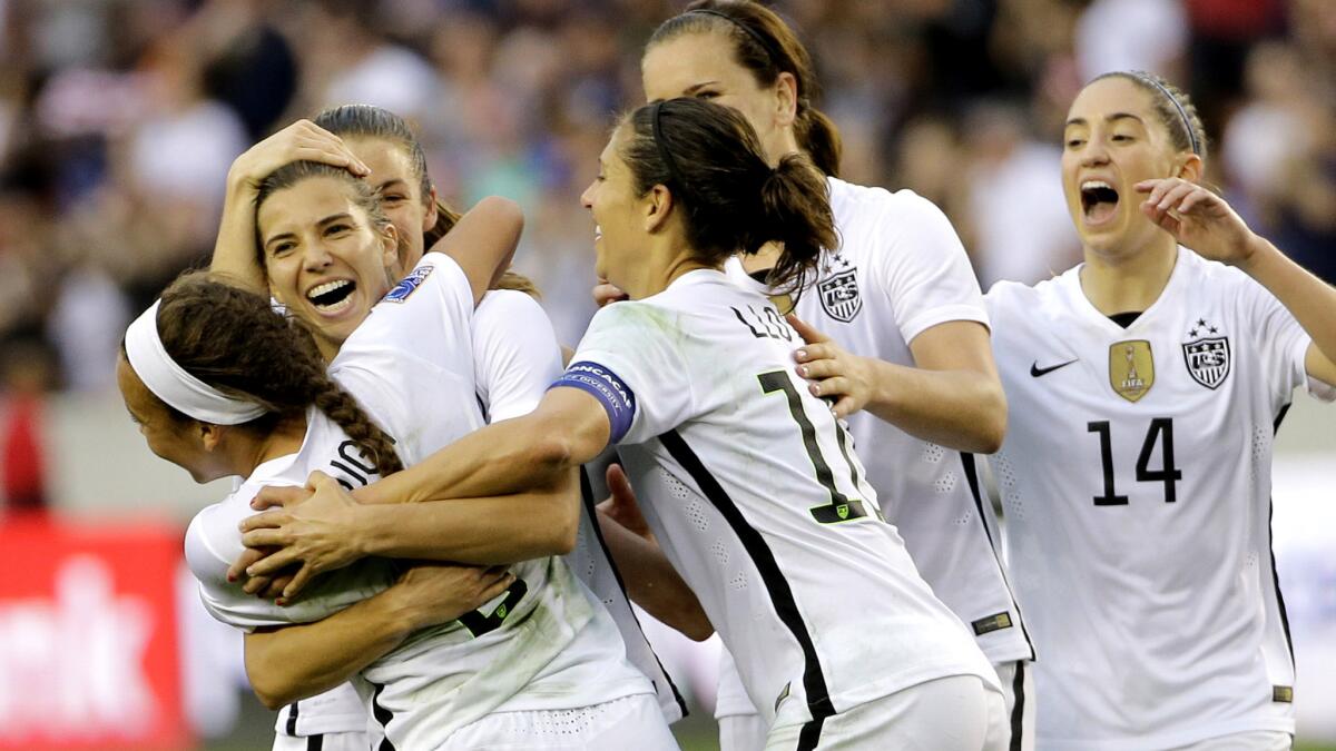 U.S. midfielder Tobin Heath, second from left, celebrates with teammates after scoring a goal against Canada during the second half of the CONCACAF Olympic women's soccer qualifying championship game Sunday.