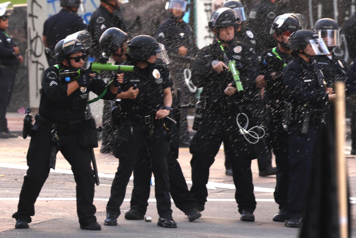 Police prepare to fire a so-called non-lethal projectile at protesters