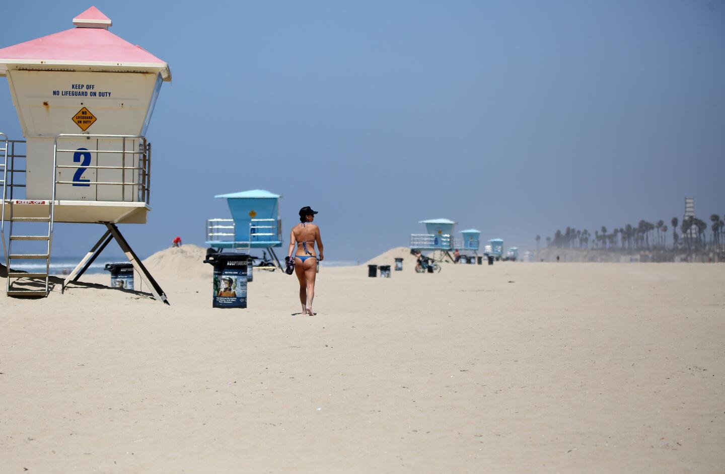 A woman walks on an almost-empty stretch of Huntington City Beach in Huntington Beach on Friday.