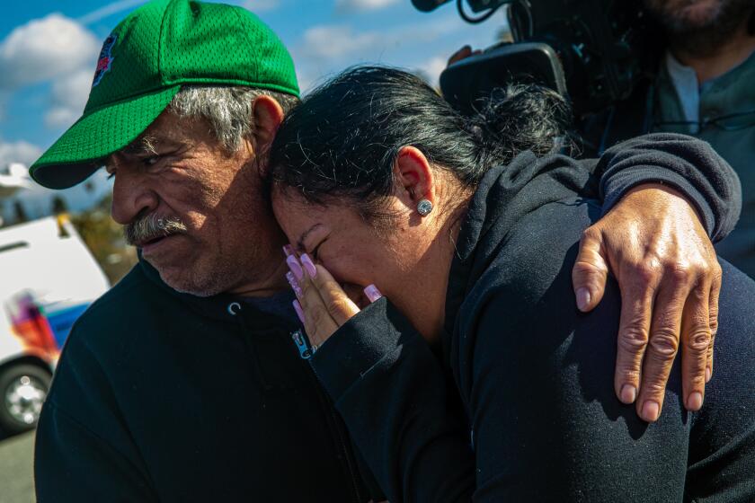 ALHAMBRA, CA - MARCH 08: Distraught grandfather Jesus Fries, left, and mother Laura Frias of 17-year-old Xavier Chavarin who was fatally stabbed last week in El Sereno, at the location where suspect barricaded himself at 2300 block of Westmont Drive on Wednesday, March 8, 2023 in Alhambra, CA. (Irfan Khan / Los Angeles Times)