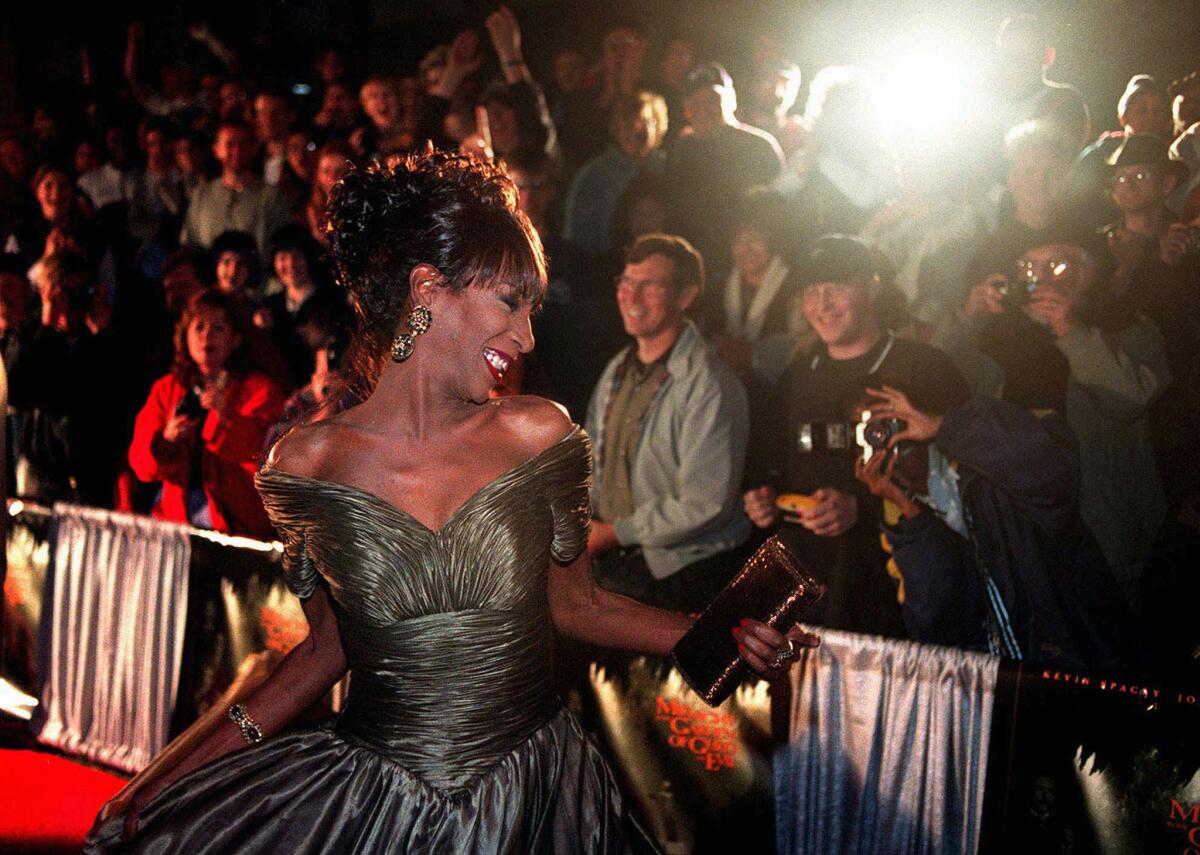 The Lady Chablis twirls for the crowd awaiting the stars of the movie "Midnight in the Garden of Good and Evil" to arrive for the premiere screening in Savannah, Ga., in 1997.