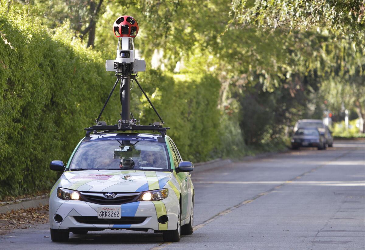 An employee drives a Google vehicle around Palo Alto, Calif.
