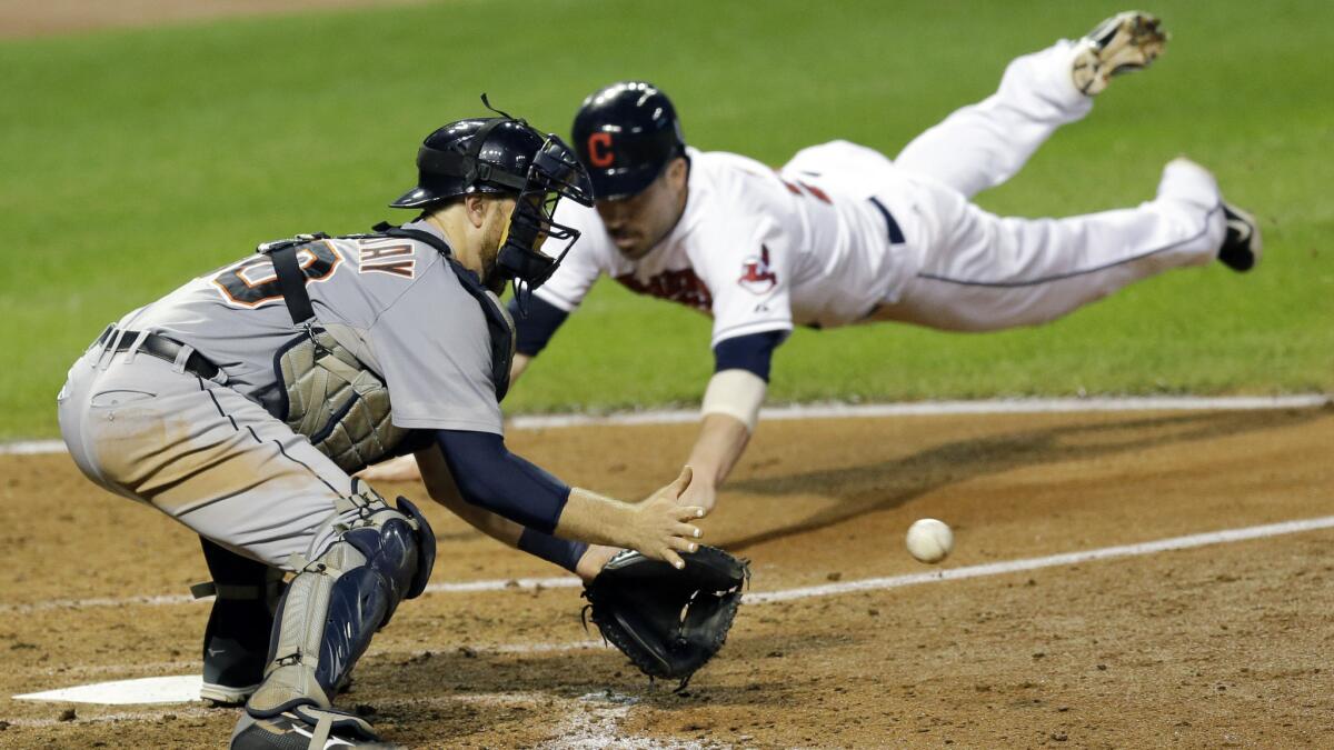 Detroit Tigers catcher Bryan Holaday, left, waits for the ball as Cleveland Indians basrunner Jason Kipnis slides safely into home during a Sept. 3 game. MLB attempted the clarify the rule regarding home plate collisions.
