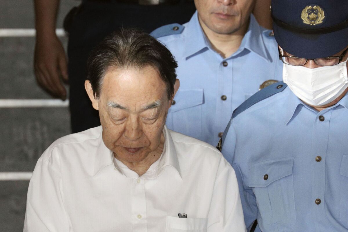 Hideaki Kumazawa, a former senior government official in Japan, is led out of a police station in Tokyo on June. 3.