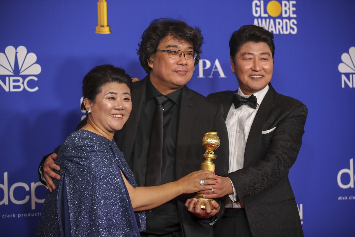 "Parasite" actors Lee Jeong Eun and Song Kang Ho flank director Bong Joon Ho at the Golden Globe Awards.