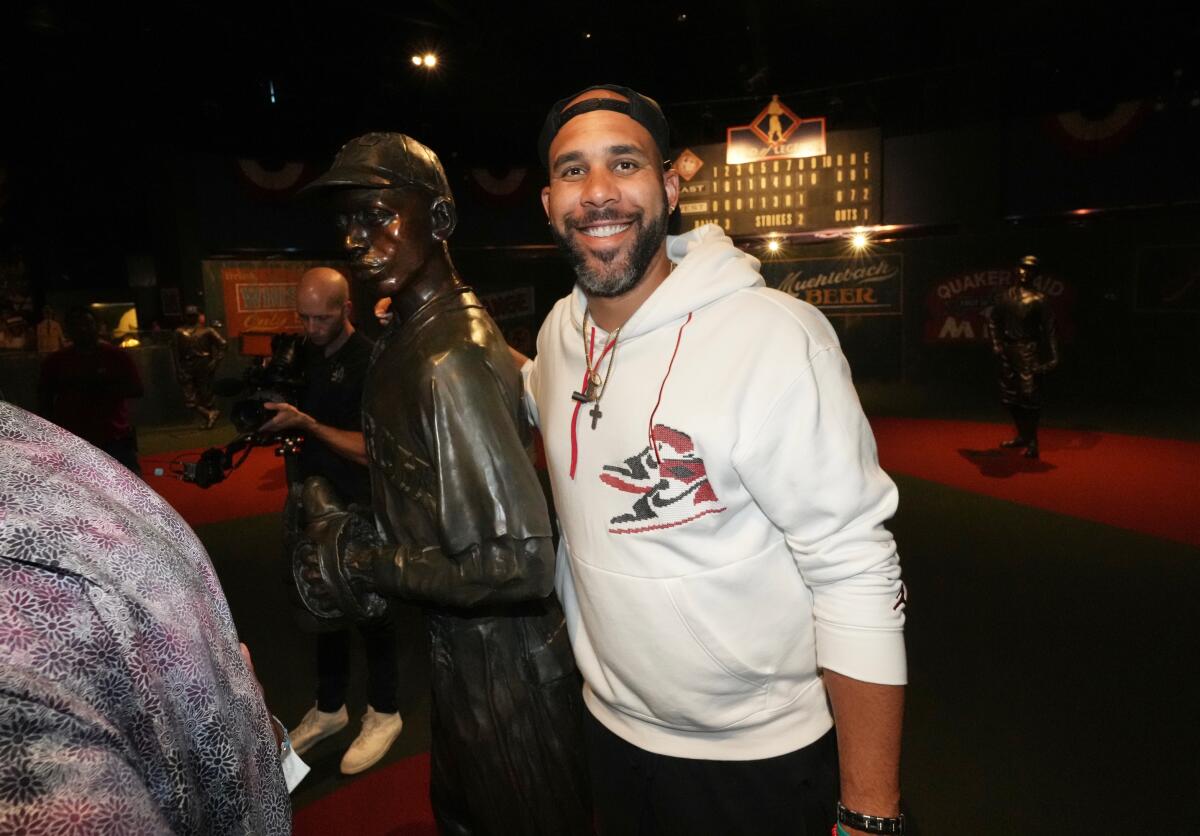 Dodgers pitcher David Price stands next to a statue at the Negro Leagues Baseball Museum in Kansas City, Mo.