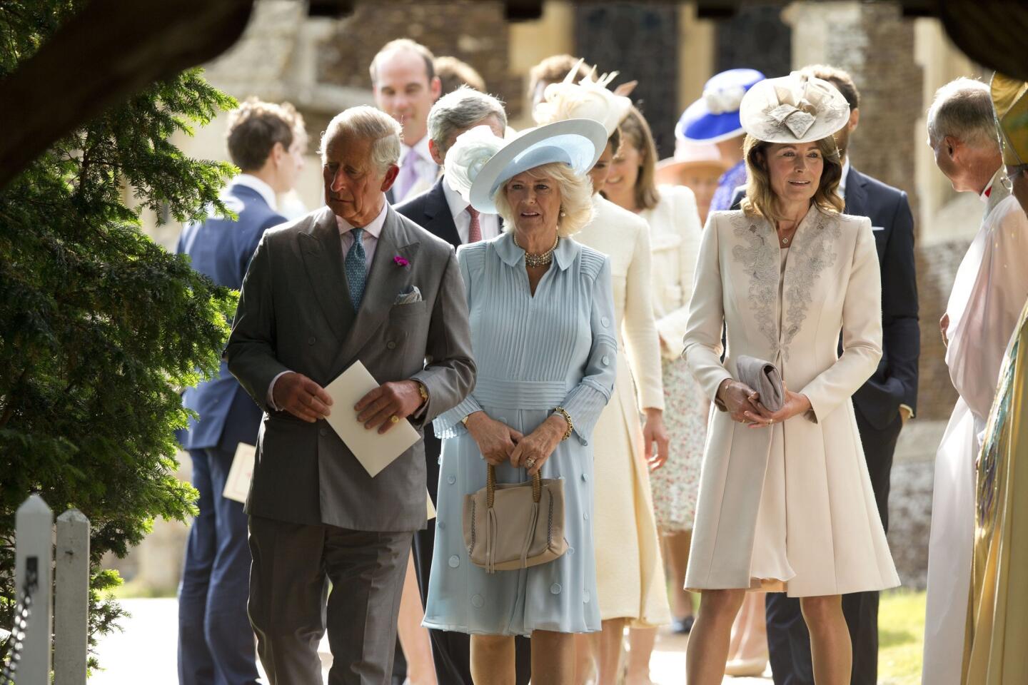 Britain's Camilla the Duchess of Cornwall, center, walks with her husband Prince Charles, left, and Kate the Duchess of Cambridge's mother Carole, right, as they leave after attending the Christening of Britain's Princess Charlotte at St. Mary Magdalene Church in Sandringham, England, Sunday, July 5, 2015.
