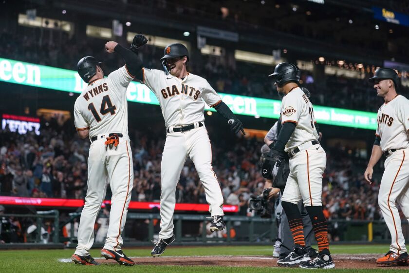 San Francisco Giants' Ford Proctor, second from left, celebrates with Austin Wynns after hitting a grand slam against the Colorado Rockies during the second inning of a baseball game in San Francisco, Thursday, Sept. 29, 2022. (AP Photo/Godofredo A. Vásquez)