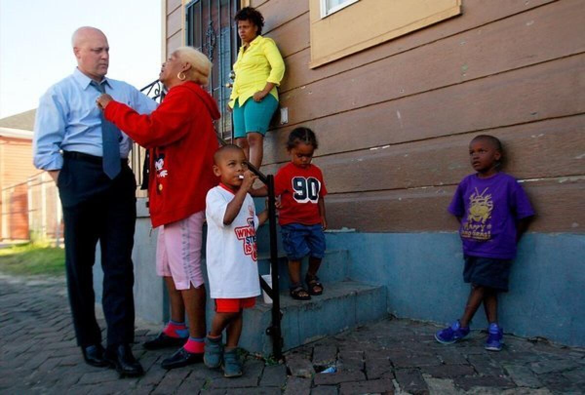 New Orleans Mayor Mitch Landrieu speaks with Jane Lewis outside her home near where a shooting occurred during a Mother's Day parade in New Orleans.
