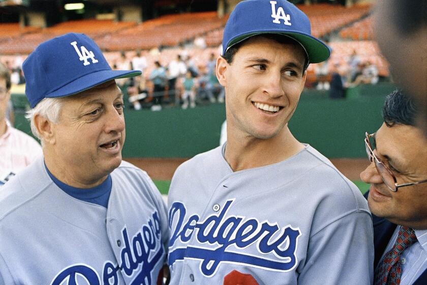Steve Sax of the Los Angeles Dodgers laughs as manager Tommy Lasorda tells a story.