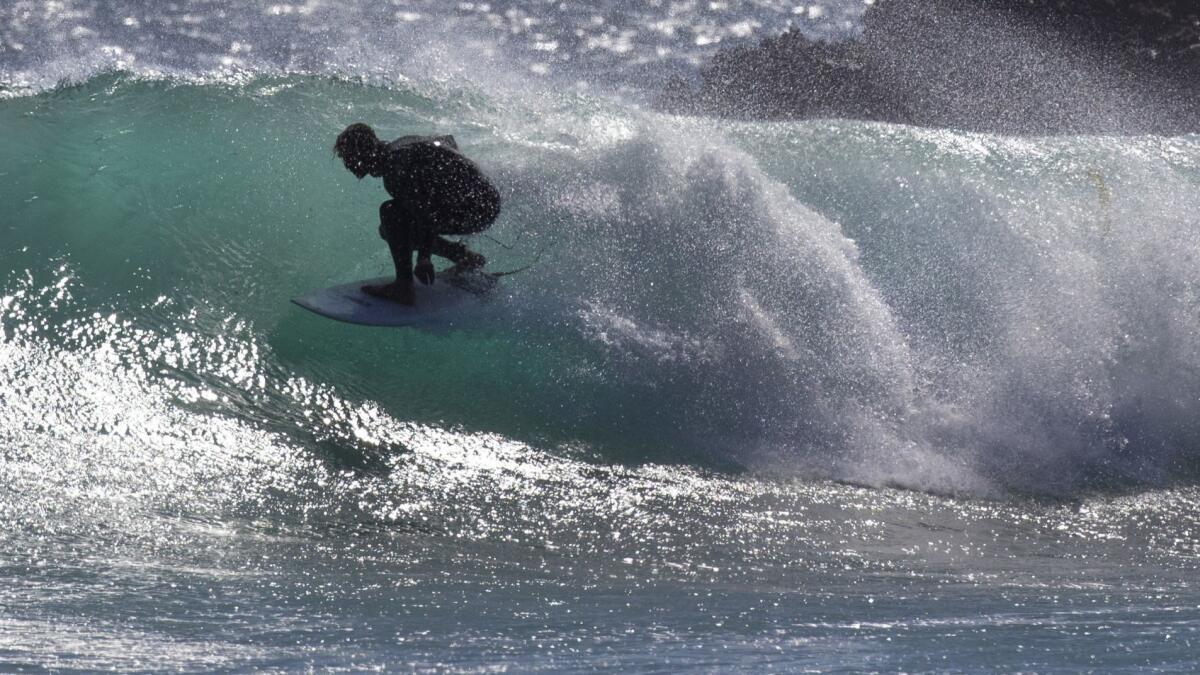 A surfer catches a wave at Leo Carrillo State Beach in Malibu on Monday.