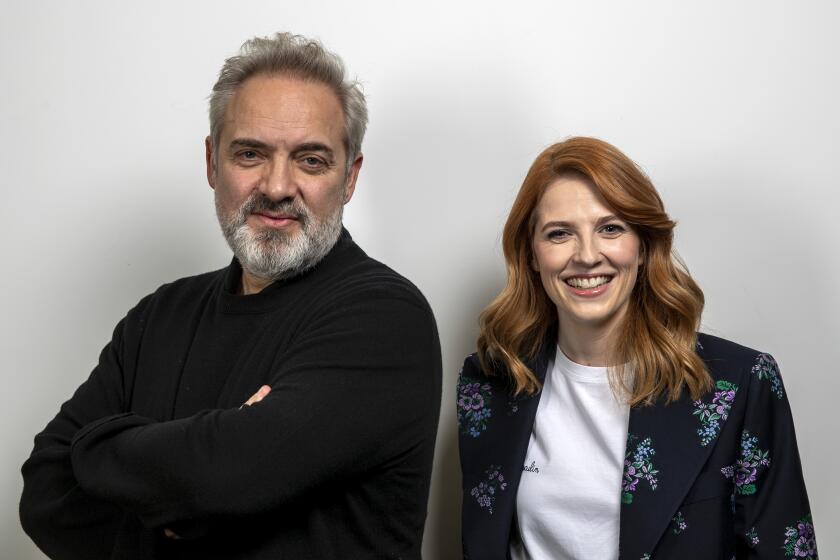 LOS ANGELES, CALIF. -- MONDAY, NOVEMBER 25, 2019: 1917 film director Sam Mendes, left, and screenwriter Kristy Wilson Cairns, right, sit for portraits at the Four Seasons Los Angeles at Beverly Hills hotel in Los Angeles, Calif., on Nov. 25, 2019. (Brian van der Brug / Los Angeles Times)