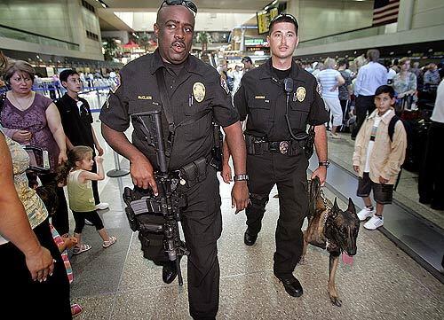 Los Angeles International Airport police officers Marshall McClain, left, and Mike Manahan patrol the Bradley international terminal after officials increased police presence Saturday following the car bombing attempts in Britain. "Out of an abundance of caution, we have increased our deployment of uniformed patrol and K-9 officers," according to a statement issued by Los Angeles World Airports. In addition to LAX, the affected facilites were Ontario International Airport, and Van Nuys and Palmdale regional airports.