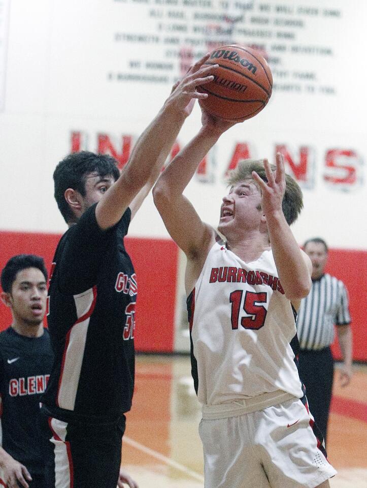 Burroughs' Nick Garcia drives to the basket to shoot but is blocked by Glendale's Elvin Hartoonian in a Pacific League boys' basketball game at Burroughs High School on Friday, January 4, 2019.