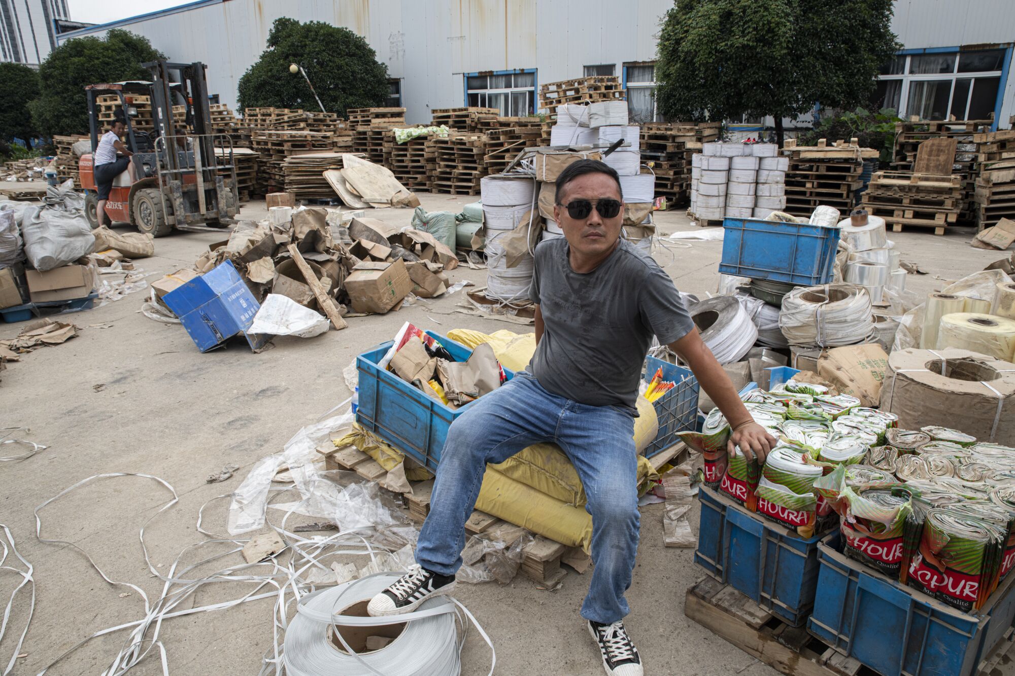 Ma Dacong sits among flooded gear to be disposed of at a tea factory in Shexian.