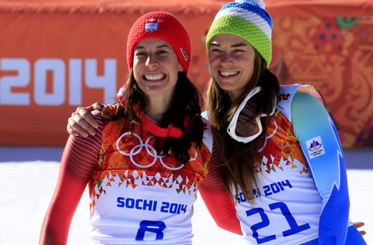 Dominique Gisin, left, and Tina Maze share the podium after tying for the gold medal in the women's downhill on Wednesday during the Sochi Olympics at the Rosa Khutor Alpine Center.