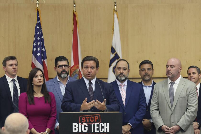 Florida Gov. Ron DeSantis gives his opening remarks flanked by local state delegation members prior to signing legislation that seeks to punish social media platforms that remove conservative ideas from their sites, inside Florida International University's MARC building in Miami on Monday, May 24, 2021. (Carl Juste/Miami Herald via AP)