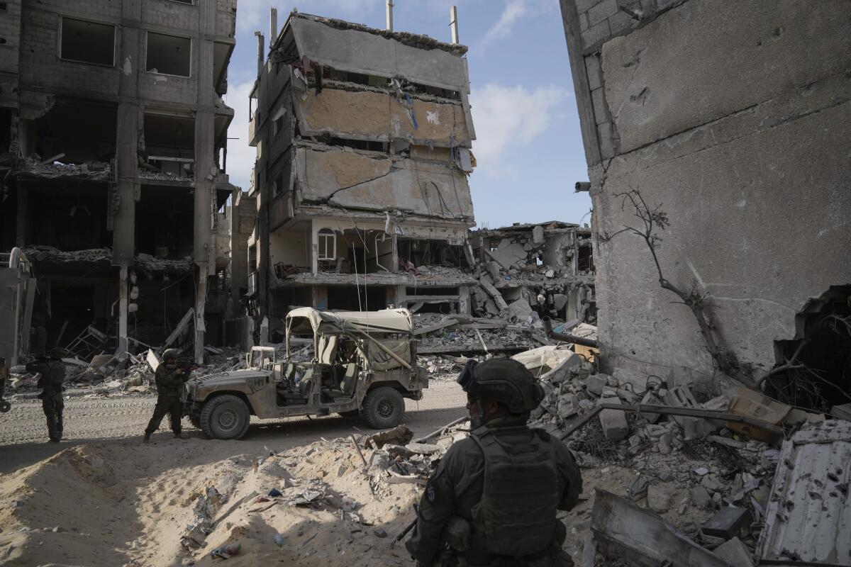 Soldiers next to ruined buildings in Gaza.