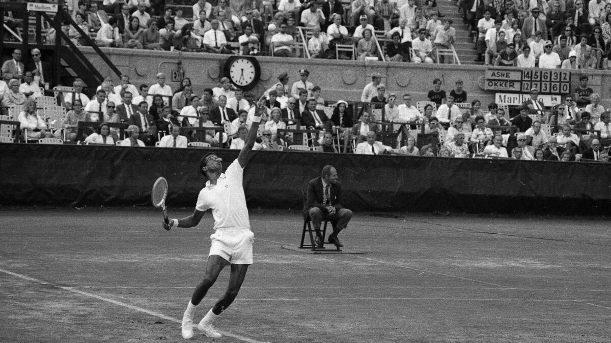 UCLA alum Arthur Ashe, who became close friends with USC alum Stan Smith, serves against Clark Graebner during the 1968 U.S. Open.