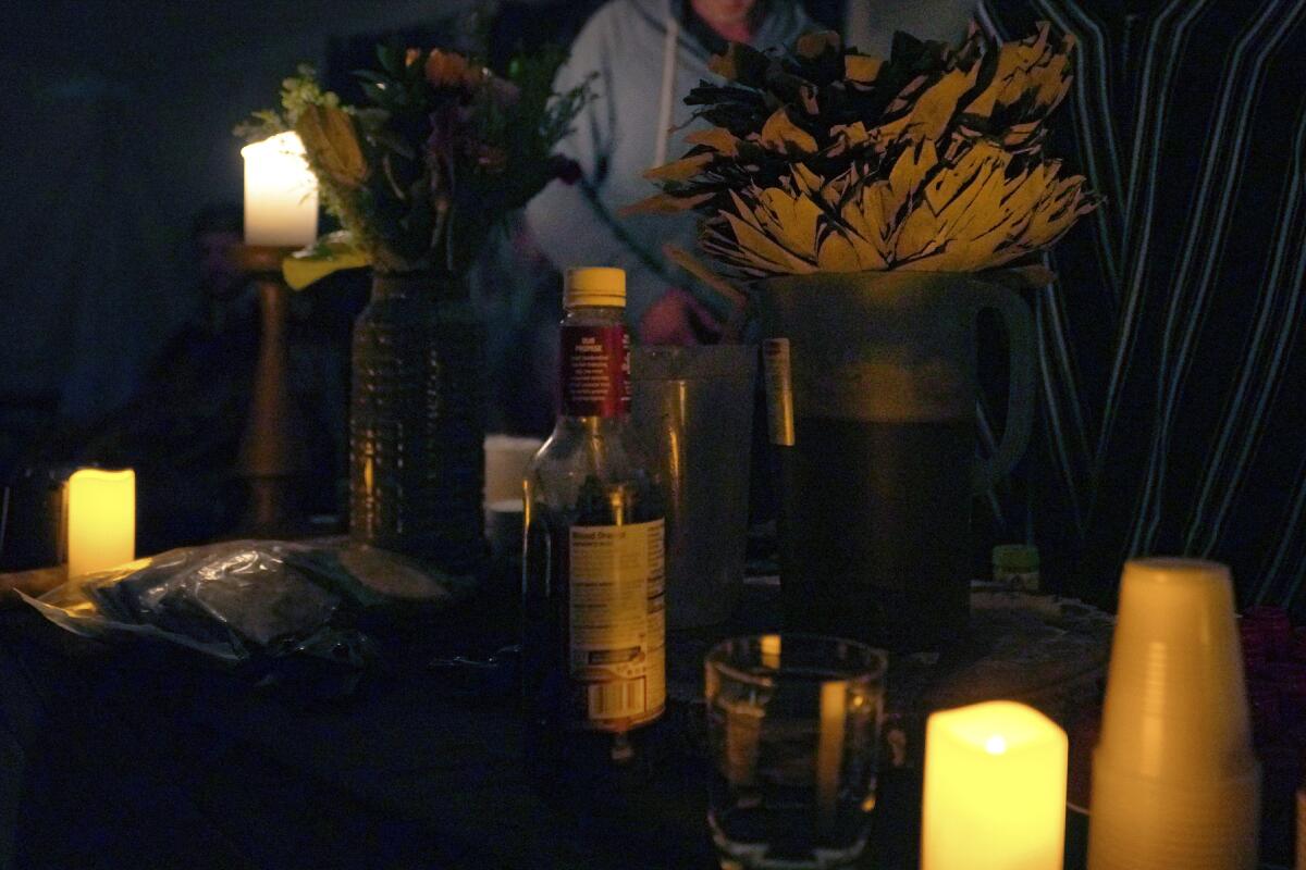 Una botella de ayahuasca es colocada en un altar durante una ceremonia espiritual de la iglesia Hummingbird 