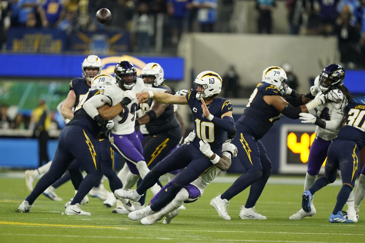 Chargers quarterback Justin Herbert (10) is tackled by Ravens cornerback Arthur Maulet on fourth down in Week 12.