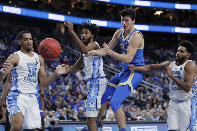 From left, North Carolina's Garrison Brooks (15) and Leaky Black, UCLA's Jaime Jaquez Jr. and UNC's Jeremiah Francis battle for the ball during the second half of an NCAA college basketball game Saturday, Dec. 21, 2019, in Las Vegas. (AP Photo/John Locher)