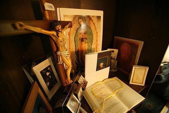 Rafael and Maria Alarcon have set up a shrine with photographs, a prayer book, rosary and Christian icons in the bedroom of their son's room in their Pasadena home Wednesday. Jorge Alarcon, who had been diagnosed schizophrenic, was found dead after an apparent suicide Monday in a county-run mental hospital.