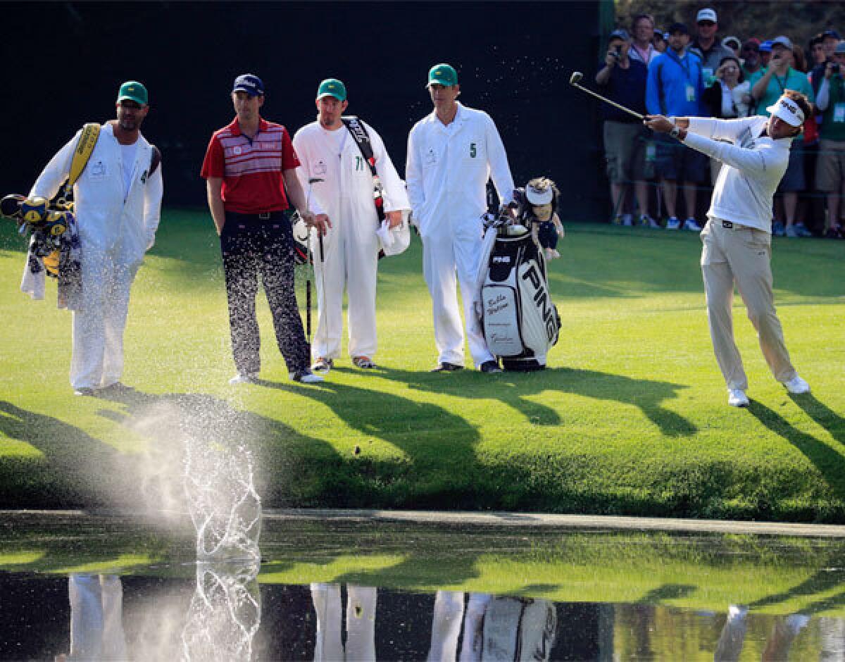 Bubba Watson skips a shot on the pond at the 16th hole as Webb Simpson and their caddies look on during a practice round Wednesday ahead of the Masters at Augusta National.